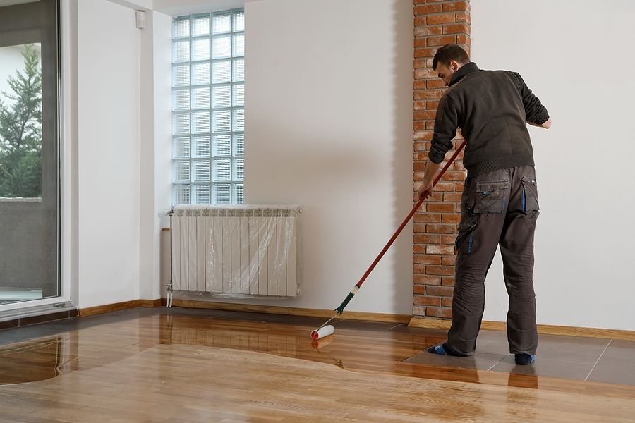 polyaspartic floor coating being applied to wooden floor